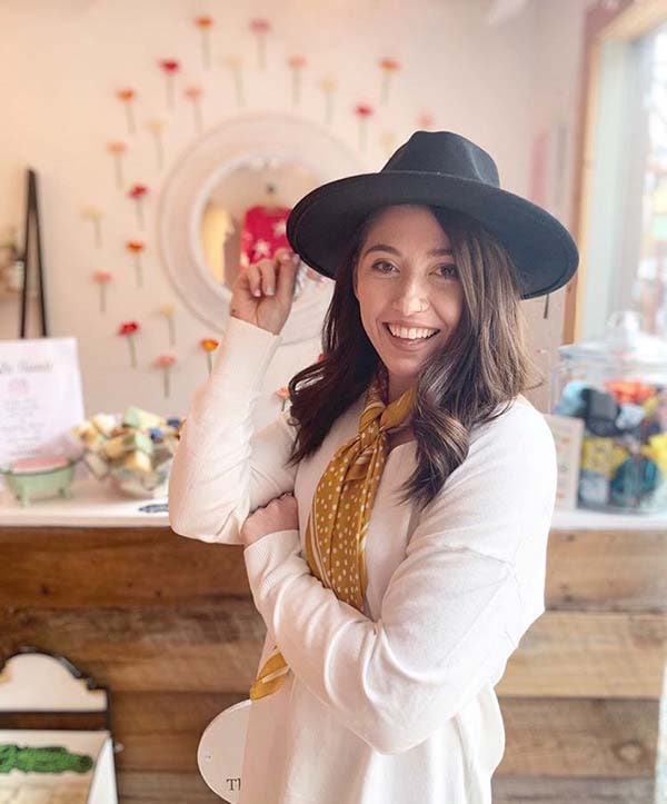 Autumn Grant, founder of The Kind Poppy, wears a hat and smiles.
